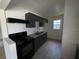 Efficient kitchen with grey cabinetry, black appliances, and a double stainless steel sink at 1506 Fairbanks St, Lakeland, FL 33805
