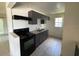 Functional kitchen with grey cabinetry, black appliances, and a double stainless steel sink at 1506 Fairbanks St, Lakeland, FL 33805