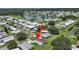 Aerial view shows a home near a tranquil pond, surrounded by greenery and houses at 1548 Longbow Dr, Lakeland, FL 33810