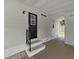 Carport featuring a door to the home and stairs with black handrails at 1548 Longbow Dr, Lakeland, FL 33810
