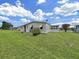 Backyard view of the single-story home with a well-maintained lawn at 1548 Longbow Dr, Lakeland, FL 33810