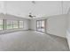 Spacious living room with neutral carpeting, ceiling fan, and large windows for natural light at 1548 Longbow Dr, Lakeland, FL 33810