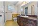 Bathroom with a vintage vanity, yellow tile accents, and a large mirror at 165 Lagoon Rd, Winter Haven, FL 33884