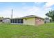 Exterior view of home featuring a screened-in porch and a well-maintained lawn at 165 Lagoon Rd, Winter Haven, FL 33884
