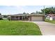 Charming single-story brick home with a well-manicured lawn and attached garage at 165 Lagoon Rd, Winter Haven, FL 33884