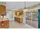 Functional kitchen features classic cabinets, yellow countertops, linoleum flooring, and access to the lanai at 165 Lagoon Rd, Winter Haven, FL 33884