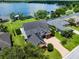 Aerial view of a well-maintained home with large driveway, manicured lawn and access to the waterfront at 1836 Woodpointe Dr, Winter Haven, FL 33884