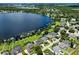 Gorgeous aerial view of lakeside homes, lush lawns, and private docks along the water at 1836 Woodpointe Dr, Winter Haven, FL 33884