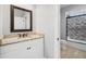 Bright bathroom featuring granite countertop, framed mirror, and tiled shower with glass door at 1836 Woodpointe Dr, Winter Haven, FL 33884