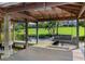 Covered dock with swing overlooking beautiful waterfront and lush green lawn in a serene neighborhood at 1836 Woodpointe Dr, Winter Haven, FL 33884