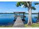 Charming dock with a gazebo and bench seating offers a perfect spot to enjoy peaceful lake views at 1836 Woodpointe Dr, Winter Haven, FL 33884