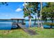 Picturesque dock featuring a covered gazebo and bench seating with tranquil views of the serene lake at 1836 Woodpointe Dr, Winter Haven, FL 33884
