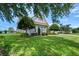 Well-maintained home exterior featuring lush green lawn, mature trees and lake view at 1836 Woodpointe Dr, Winter Haven, FL 33884
