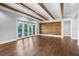 Bright living room featuring wooden ceiling beams, hardwood floors, and sliding glass doors at 1836 Woodpointe Dr, Winter Haven, FL 33884