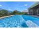 Inviting pool with a serene view, surrounded by lush landscaping and a stylish patio area at 1836 Woodpointe Dr, Winter Haven, FL 33884