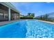 Sparkling pool with clear blue water and a black fence, perfect for relaxing and enjoying the sunny outdoors at 1836 Woodpointe Dr, Winter Haven, FL 33884
