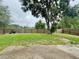 View of the spacious backyard with a large tree and wooden fence at 1844 Emily Dr, Winter Haven, FL 33884
