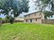 Large fenced backyard with a mature tree and sliding glass door to the house at 1844 Emily Dr, Winter Haven, FL 33884