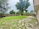 Expansive backyard featuring a lush lawn, mature tree, and partial patio at 1844 Emily Dr, Winter Haven, FL 33884