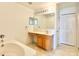 Bathroom features a vanity, mirror, bathtub, and linen closet with tiled floors at 1844 Emily Dr, Winter Haven, FL 33884