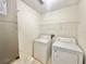 Functional laundry room with a washer, dryer, and storage shelving at 1844 Emily Dr, Winter Haven, FL 33884