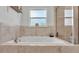 Relaxing soaking tub with neutral tile surround, a framed window, and a glass enclosed shower at 195 Kissengen Park Blvd, Bartow, FL 33830