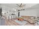 Bright, open-concept living room and kitchen featuring wood floors, a ceiling fan, and barstool seating at 195 Kissengen Park Blvd, Bartow, FL 33830