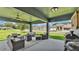 Covered patio has comfortable seating, ceiling fan, string lights, and view of the lush yard at 195 Kissengen Park Blvd, Bartow, FL 33830