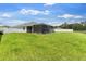 Large backyard with lush green grass, screened-in lanai, and a white fence at 1976 Harvest Landing Cir, Lakeland, FL 33810