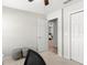 A serene bedroom view shows an open doorway to another bedroom, two ottomans, and a closet at 1976 Harvest Landing Cir, Lakeland, FL 33810