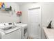 Convenient laundry room featuring modern washer and dryer, shelving, and counter space at 1976 Harvest Landing Cir, Lakeland, FL 33810