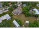 An aerial perspective of a home with a large yard, sheds, trees, and surrounding neighborhood at 208 Lake Dale Dr, Auburndale, FL 33823