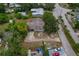 Aerial view of a single-Gathering home with mature trees and a driveway leading to an attached garage at 208 Lake Dale Dr, Auburndale, FL 33823