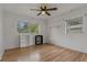A bright bedroom with wood floors, ceiling fan, and a window offering outside views at 208 Lake Dale Dr, Auburndale, FL 33823