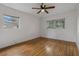 Spacious bedroom featuring hardwood floors, a ceiling fan, and two windows for ample natural light at 208 Lake Dale Dr, Auburndale, FL 33823