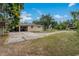 Side exterior view showing a spacious driveway leading to the home and detached garage at 208 Lake Dale Dr, Auburndale, FL 33823
