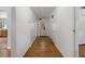 Hallway featuring hardwood floors, neutral walls, and access to the kitchen and to the back door at 208 Lake Dale Dr, Auburndale, FL 33823