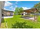 Spacious backyard featuring a covered patio, lush lawn, and a storage shed at 216 Pike St, Auburndale, FL 33823