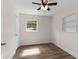 Cozy bedroom featuring wood-look floors, ceiling fan and a window at 216 Pike St, Auburndale, FL 33823
