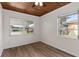 Bright bedroom featuring wood-look floors, a wood ceiling, and views of the street at 216 Pike St, Auburndale, FL 33823