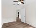 Neutral bedroom featuring wood-look floors, ceiling fan, and a white door at 216 Pike St, Auburndale, FL 33823