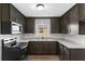 Modern kitchen featuring dark cabinets, subway tile backsplash, and stainless steel appliances at 216 Pike St, Auburndale, FL 33823