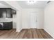 Bright living room featuring wood-look floors, white trim, and a view into the kitchen with dark cabinets at 216 Pike St, Auburndale, FL 33823
