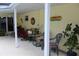 Cozy covered patio with brick walls, comfortable seating, decorative elements, and inviting plants at 217 Shore Loop, Winter Haven, FL 33884