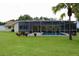 Backyard pool area with a screened-in enclosure, surrounded by a lush green lawn and charming potted plants at 217 Shore Loop, Winter Haven, FL 33884