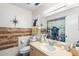 Well-lit bathroom with decorative mirror, modern vanity, and stylish wood-look accent wall at 2282 Firestone Pl, Winter Haven, FL 33884