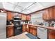 Functional kitchen space with wooden cabinets, stainless steel appliances, and laminate flooring at 2282 Firestone Pl, Winter Haven, FL 33884