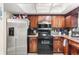 Spacious kitchen with wooden cabinets, stainless steel refrigerator, and black appliances at 2282 Firestone Pl, Winter Haven, FL 33884