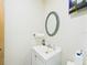 Bathroom features a white vanity, decorative mirror and stained glass, offering a clean and stylish aesthetic at 2418 W 1St St, Sanford, FL 32771