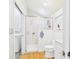 Bright bathroom featuring tiled shower, toilet, sink, and laundry area for convenience at 2418 W 1St St, Sanford, FL 32771
